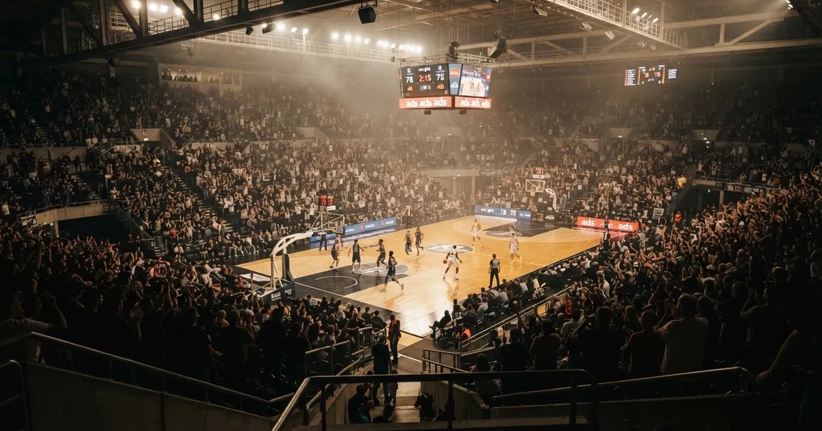 Een volle sporthal onder schijnwerpers, van grote afstand gefotografeerd